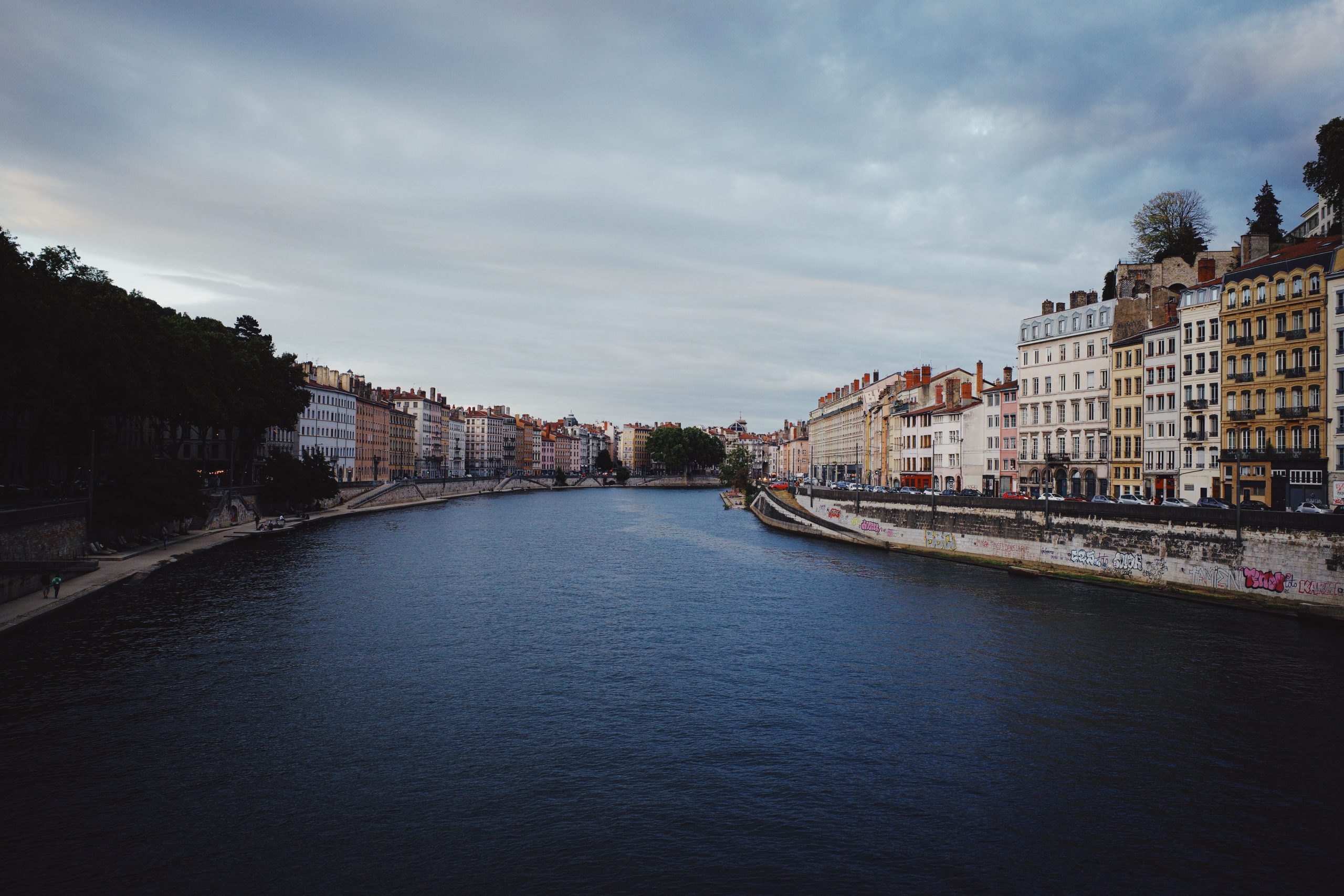 Architecture riveraine de Lyon sous ciel dramatique