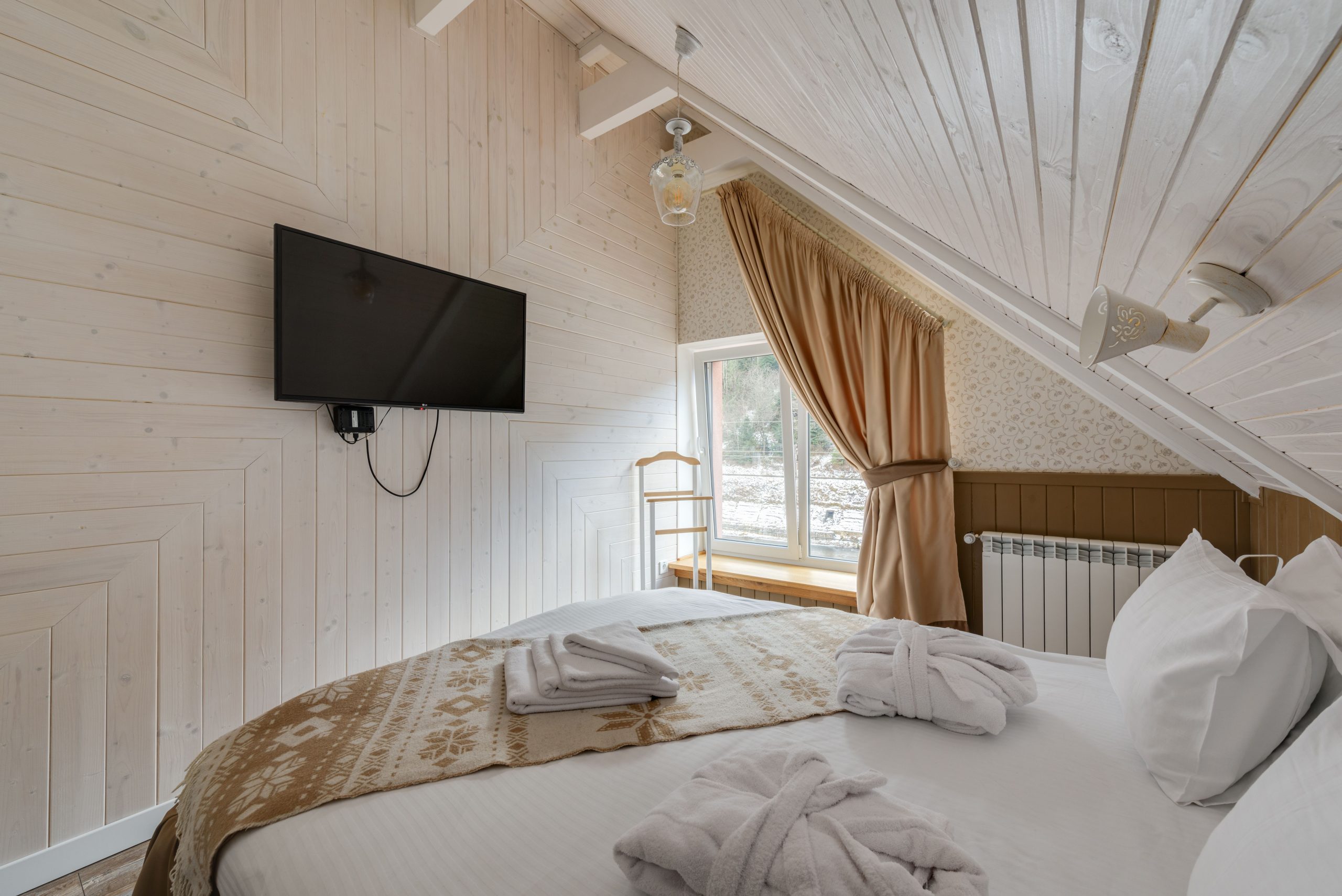 Chambre mansardée sereine avec télévision et décoration