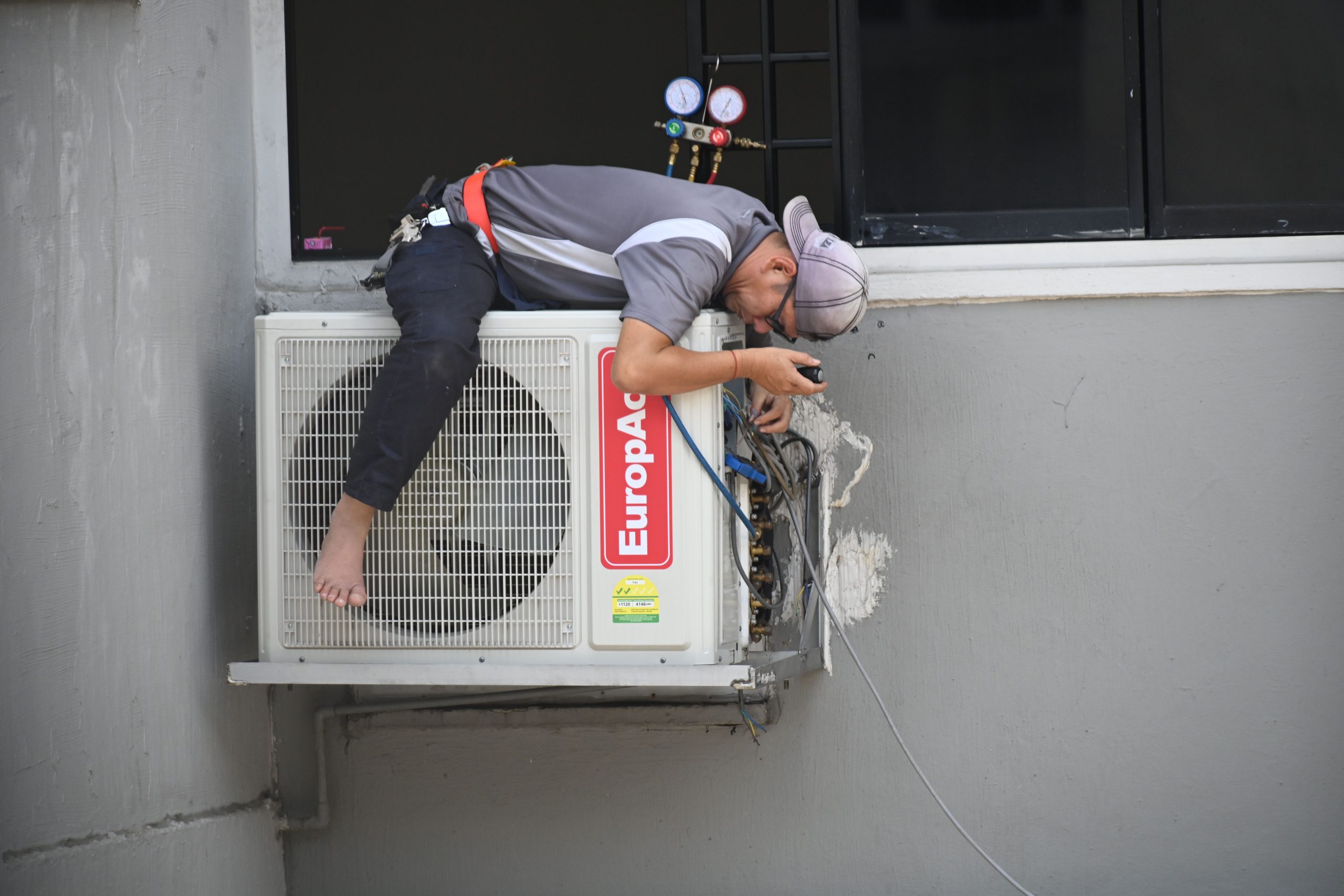 Technicien réparant une unité climatisation murale